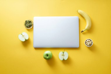 smartphone ve çiçeklerle kahve fincanı ve parlak zeytin sarı arka plan kavramı kadın blogger çalışma alanının üstünde laptop ile alay et 