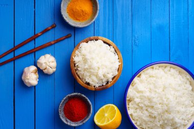 kase pişmiş pirinç Yasemin ve çubuk mavi ahşap arka plan üzerinde renkli baharat