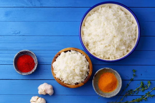 Bowls Cooked Jasmine Rice Colorful Spices Blue Wooden Background — Stock Photo, Image