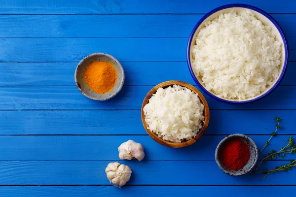 Bowls Cooked Jasmine Rice Colorful Spices Blue Wooden Background — Stock Photo, Image