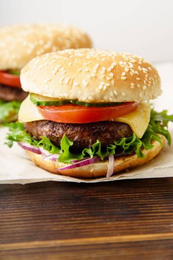 Mutfak parşömen kağıt kağıda sığır köftesi ile klasik Burger ve domates peynir ve salata ile servis 