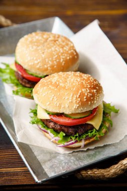 sığır köftesi ile klasik Burger ve domates peynir ve metal tepsi marul ahşap masaya servis 