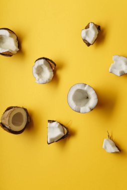 Organik olgun kırık sarı zemin üzerinde düzenlenmiş hindistancevizi yakın çekim 