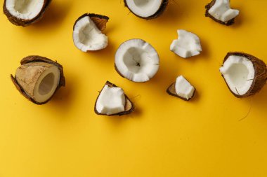 lezzetli taze Hindistan cevizi yarısı ve parçalar üzerinde sarı arka plan, üstten görünüm  