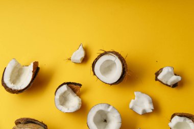 lezzetli taze Hindistan cevizi yarısı ve parçalar üzerinde sarı arka plan, üstten görünüm  