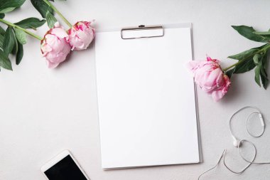  kadınsı Resepsiyon çalışma alanı boş boş Pano ve smartphone ile pembe şakayık çiçekleri, üstten görünüm