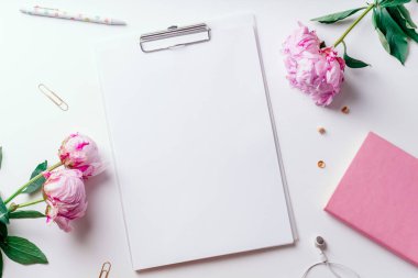 Pembe piyonlar ve Pano ile boş kağıt beyaz arka plan üzerinde romantik kavramı izole kadınsı çalışma alanı