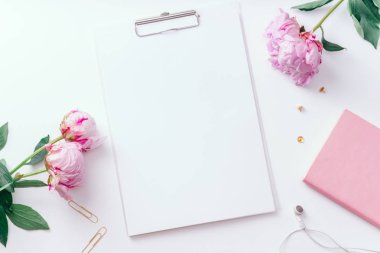 Pembe piyonlar ve Pano ile boş kağıt beyaz arka plan üzerinde romantik kavramı izole kadınsı çalışma alanı