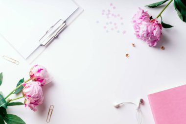 Pembe piyonlar ve Pano beyaz arka plan üzerinde romantik kavramı izole defter ile kadınsı çalışma alanı