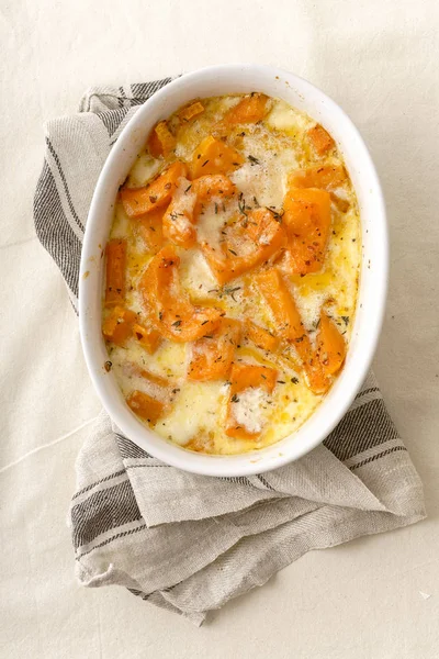 white bowl with roasted squash baked with heavy cream and thyme with white wine