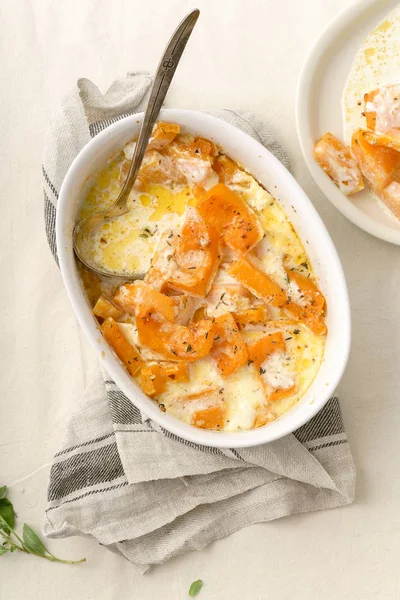 bowl and plate with Roasted squash baked and heavy cream with thyme and white wine
