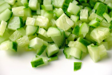 Beyaz arka plan üzerinde izole salata yemek pişirmek için ince doğranmış taze salatalık yakın çekim 