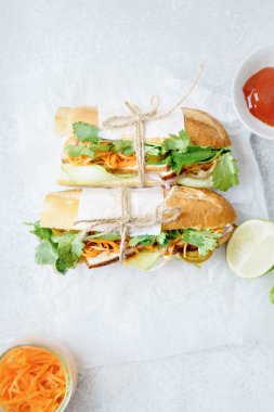 Klasik Banh'da mi sandviç dize ve soslu beyaz mutfak parşömen kağıt üzerine kireç ile kase bağladılar