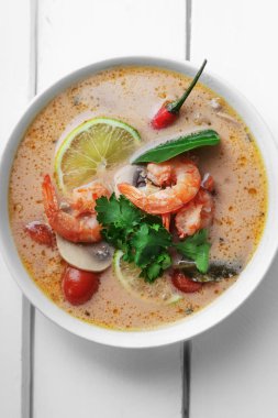 geleneksel Tay çorbası tom yum karides ve mantarlı beyaz rustik ahşap arka plan taze limon dilimleri ile servis ile kase