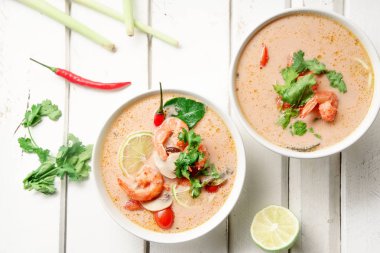 kase ile geleneksel Tay çorbası tom yum karides ve mantar ile beyaz rustik ahşap arka plan taze limon dilimleri ile servis
