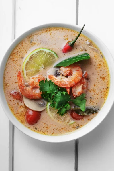 geleneksel Tay çorbası tom yum karides ve mantarlı beyaz rustik ahşap arka plan taze limon dilimleri ile servis ile kase