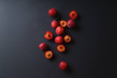 Bütün ve yarıya koyu arka plan üzerinde kırmızı tatlı kiraz Erik 