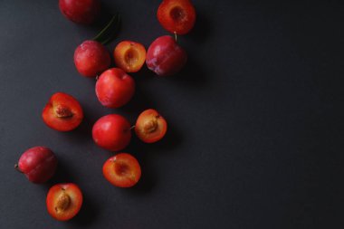Bütün ve yarıya koyu arka plan üzerinde kırmızı tatlı kiraz Erik 