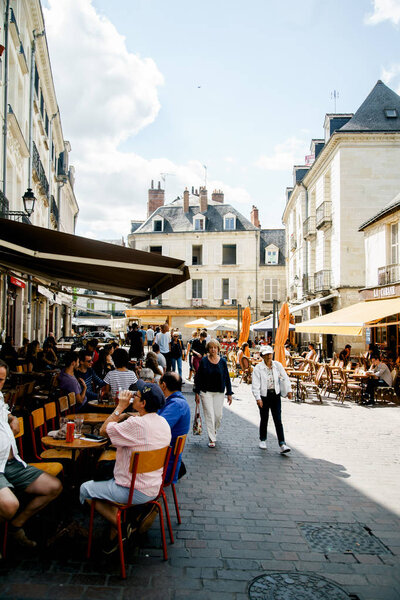 ТУРЫ, ФРАНЦИЯ - 14 августа 2018 года: вид на улицу с традиционными французскими зданиями и люди, отдыхающие в ресторанах с прекрасной летней атмосферой
