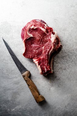 Metalik arka plan üzerinde bıçak ile ham sığır eti biftek
