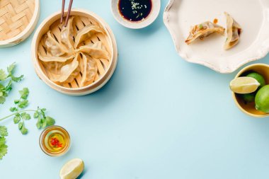 Tabakta soya sosu ve susam üzerinde mavi arka plan, üstten görünüm ile bambu vapur pişmiş ördek sosu köfte