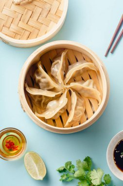 Tabakta soya sosu ve susam üzerinde mavi arka plan, üstten görünüm ile bambu vapur pişmiş ördek sosu köfte