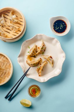 Tabakta soya sosu ve susam üzerinde mavi arka plan, üstten görünüm ile bambu vapur pişmiş ördek sosu köfte