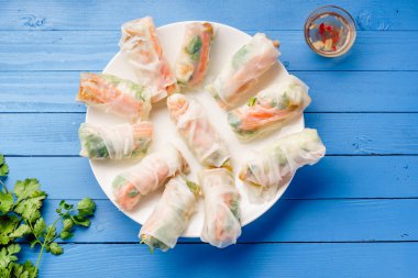 Vejetaryen böreği ile tofu ve daikon ve Salantro ile marine edilmiş havuç mavi boyalı ahşap masa üzerinde beyaz tabakta servis