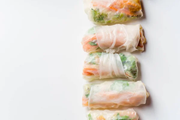 Vegetarian spring rolls with tofu and marinated carrot with daikon and cilantro isolated on white background, close-up