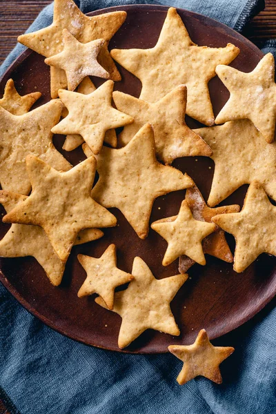 Swedish ginger cookies in star shapes on brown plate, Christmas concept