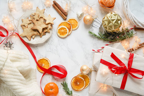 Christmas arrangement of gingerbread cookies with tangerines and new year decorations on marble background