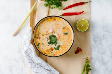geleneksel Tay Baharatlı karides ile Tom yum çorbası ahşap kişniş ve limon dilimleri ile servis kase masa, yakın çekim kesme 