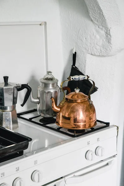 French copper teapot on white stove in kitchen