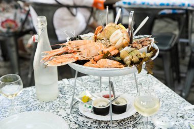 Plate with fresh assorted seafood in french summer restaurant  clipart