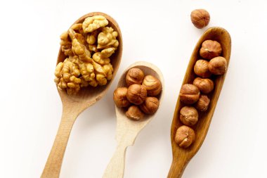 Ceviz ve fındık tahta kaşıklar beyaz arka plan üzerinde izole içinde. Üstten görünüm