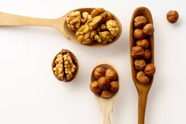 Ceviz ve fındık tahta kaşıklar beyaz arka plan üzerinde izole içinde. Üstten görünüm