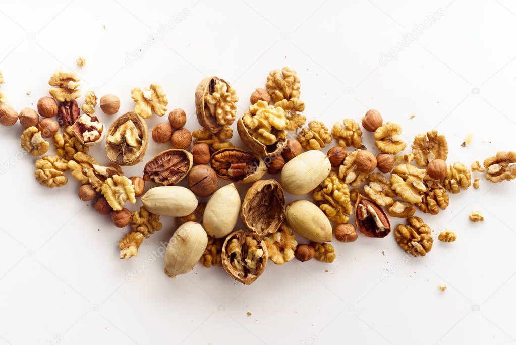 group of nuts with nutshells isolated on white background, close-up, top view 