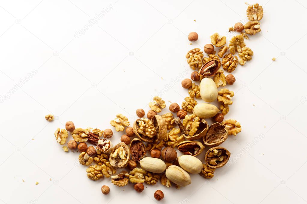 group of nuts with nutshells isolated on white background, close-up, top view 