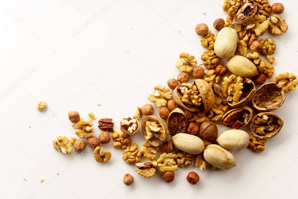 group of nuts with nutshells isolated on white background, close-up, top view 