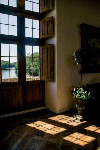 Chenonceau castle window with view at river and beautiful shadows on floor
