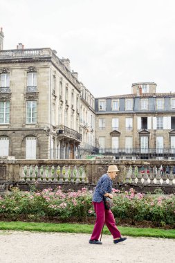 Bordeaux, Fransa - 24 Ağustos 2018: yaşlı kadın klasik Fransız binalar ve bahçenizi önünde yürüyüş
