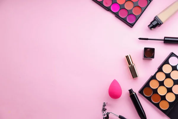 財団とパステル ピンクの背景 メイクアップ アーティスト キット概念アイラッシュカーラーでマスカラー口紅とコンシーラー パレット — ストック写真