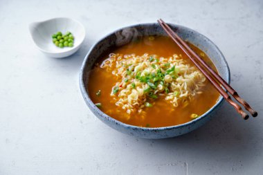 Kolay Japon ramen erişte ve yumurta ve pırasa ahşap çubuk beton zemin üzerine mavi el yapımı seramik kase Domuz eti et suyu ile
