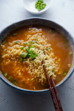 Kolay Japon ramen erişte ve yumurta ve pırasa ahşap çubuk beton zemin üzerine mavi el yapımı seramik kase Domuz eti et suyu ile