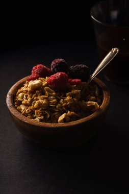 Granola ahududu ve böğürtlen ahşap kase ile. Üstten görünüm,