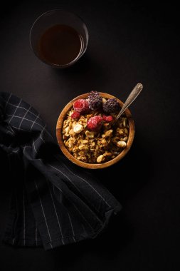 Ahududu ve böğürtlen Kupası ahşap kase kahve siyah masada granola 