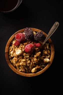Granola ahududu ve böğürtlen ahşap kase ile. Üstten görünüm,