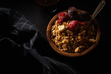 Granola ahududu ve böğürtlen ahşap kase ile. Üstten görünüm,