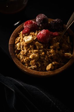 Granola ahududu ve böğürtlen ahşap kase ile. Üstten görünüm,
