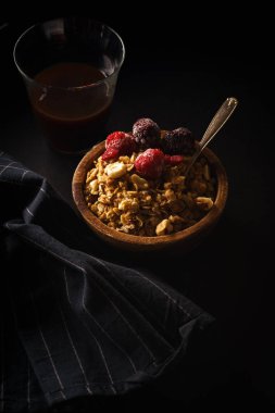 Ahududu ve böğürtlen Kupası ahşap kase kahve siyah masada granola 